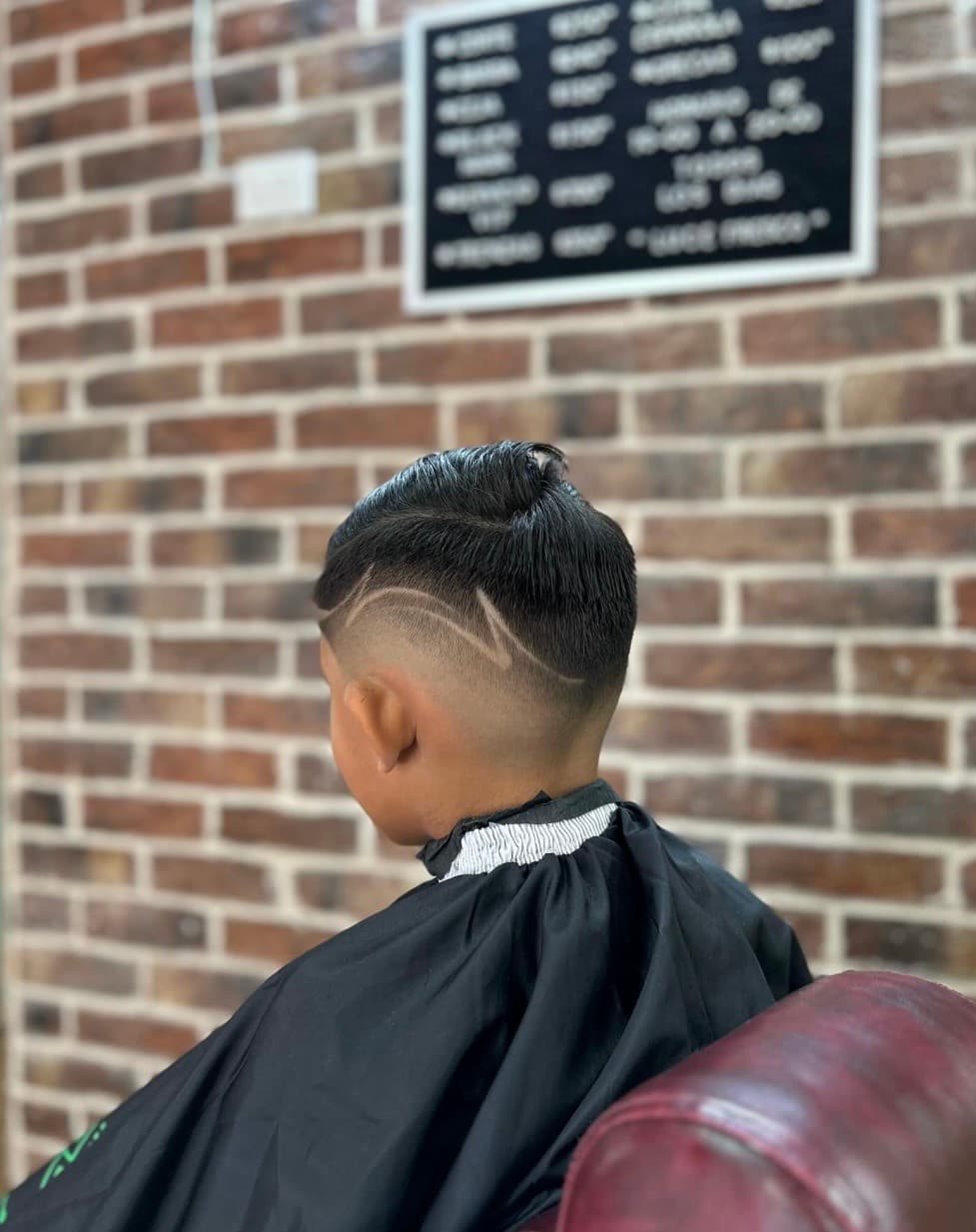 Corte infantil con fade y diseño de líneas en Mambas Barbería