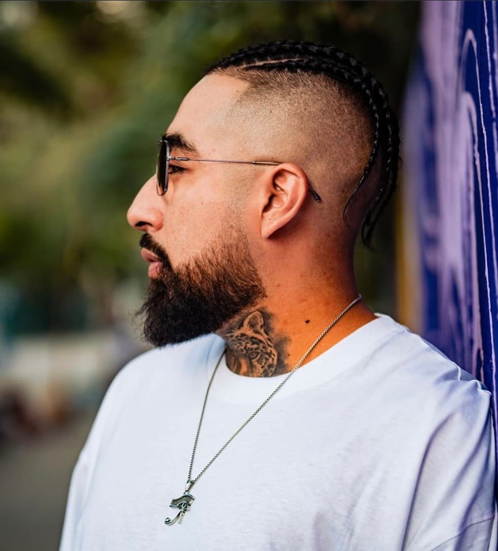Corte fade con trenzas y barba perfilada de Mambas Barbería