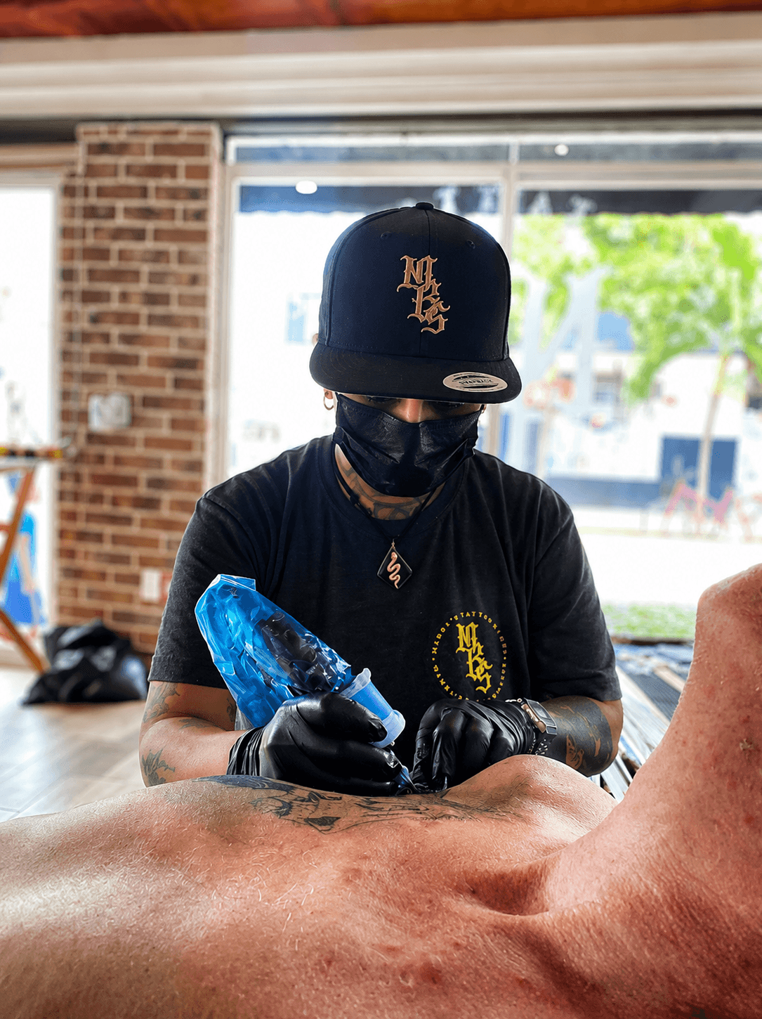 Tatuador de Mambas trabajando en una pieza durante sesión