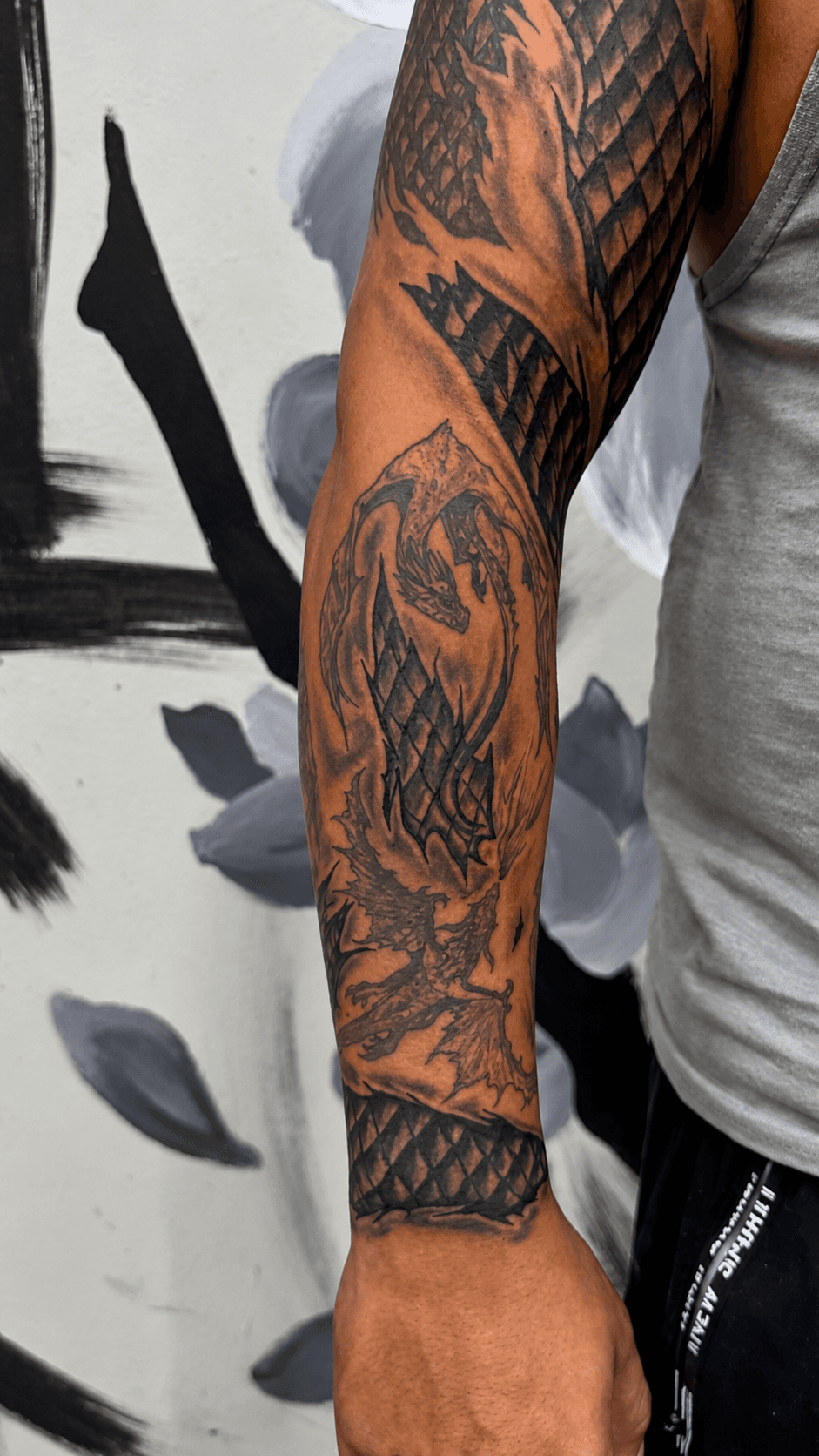Tatuaje de manga con dragón y sombreado negro realizado por Mambas Tattoo